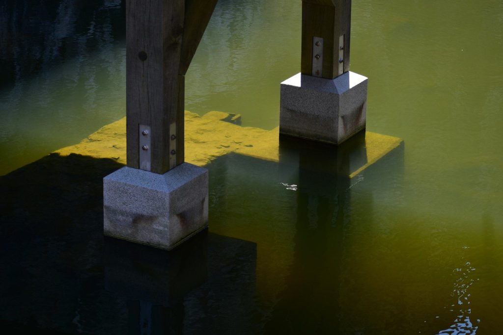 a couple of concrete pillars sitting in the middle of a body of water