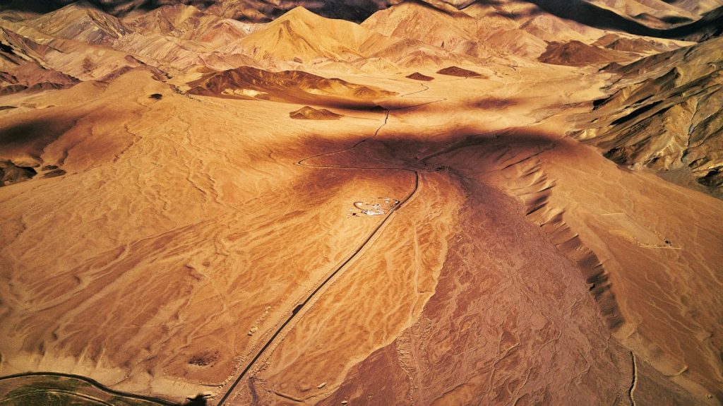 an aerial view of a valley with mountains in the background