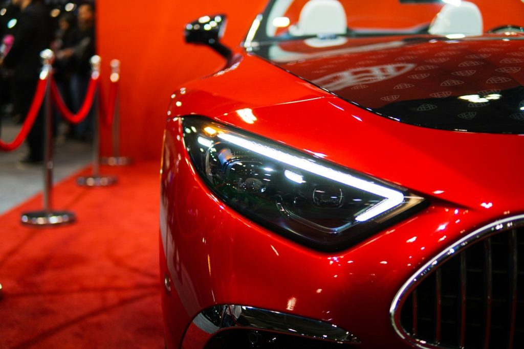 A sleek red sports car on a red carpet.
