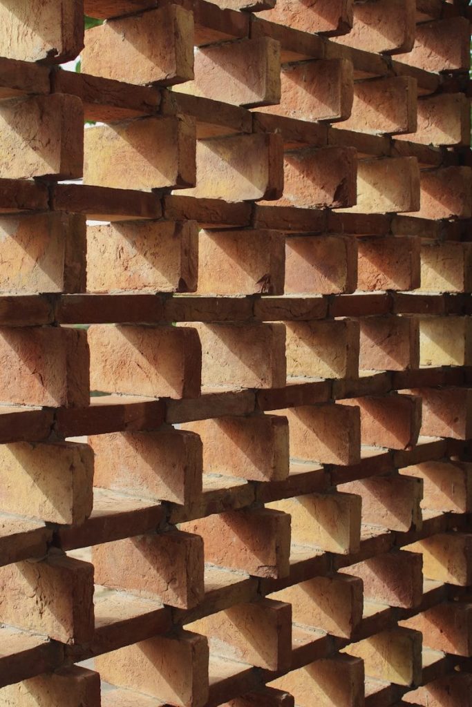 Geometric brick wall casting shadows in sunlight.
