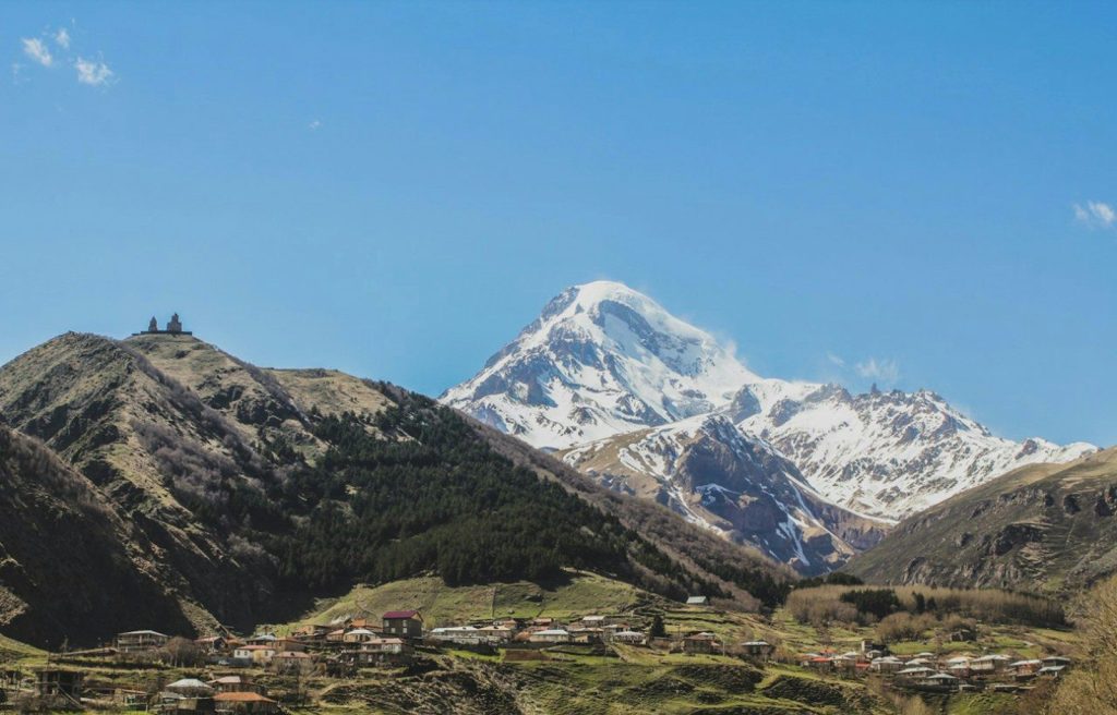 Snow-capped mountain range above a small village