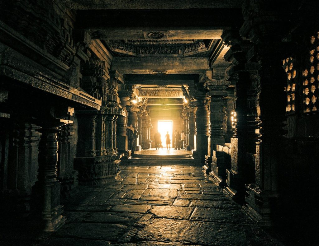 Sunlight streams into ancient stone temple corridor