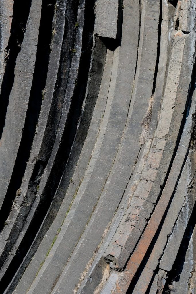 a bird is perched on the edge of a stone structure