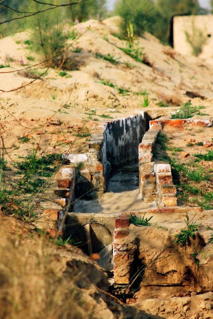 a stone bench sitting on top of a dirt hill