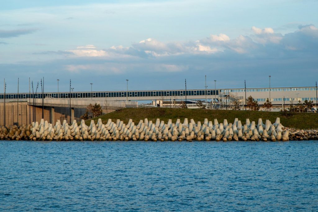 Concrete barriers protect a bridge over blue water