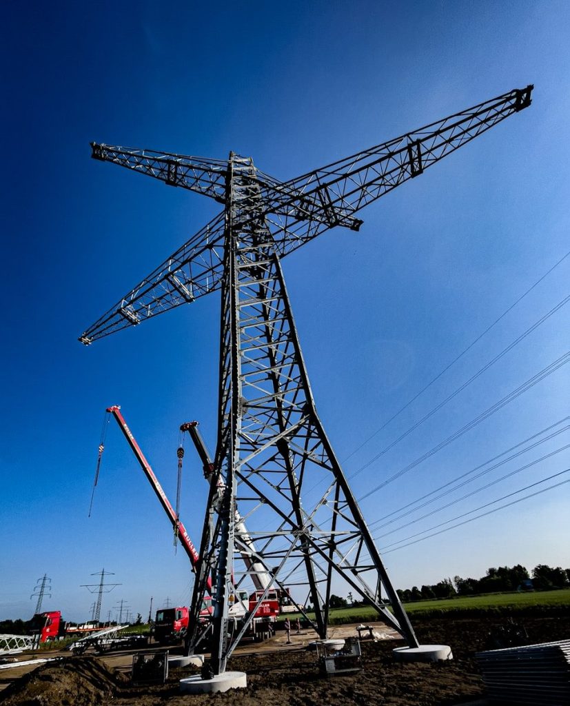 a large metal tower sitting on top of a dirt field