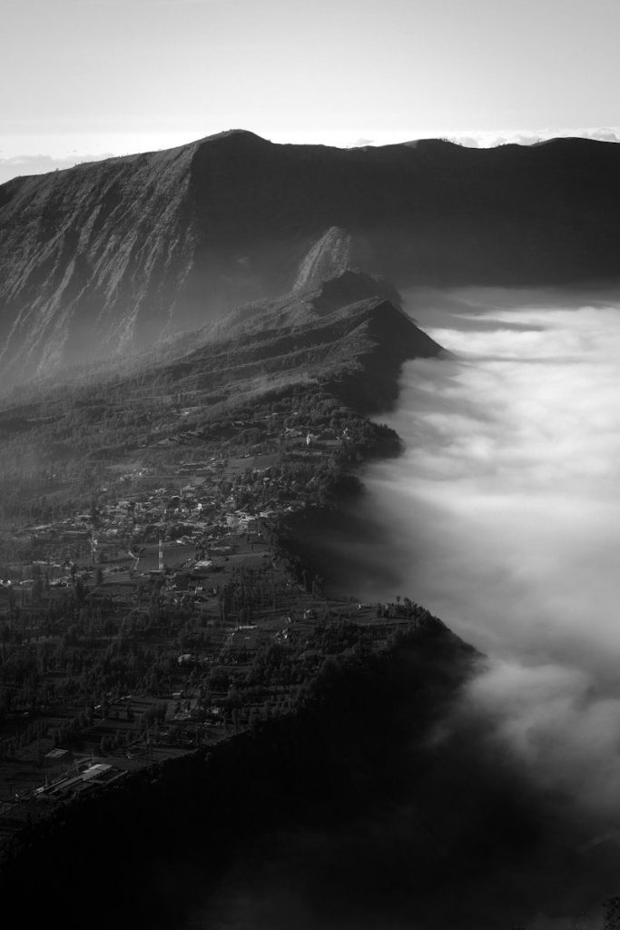 A village nestled between mountains and fog