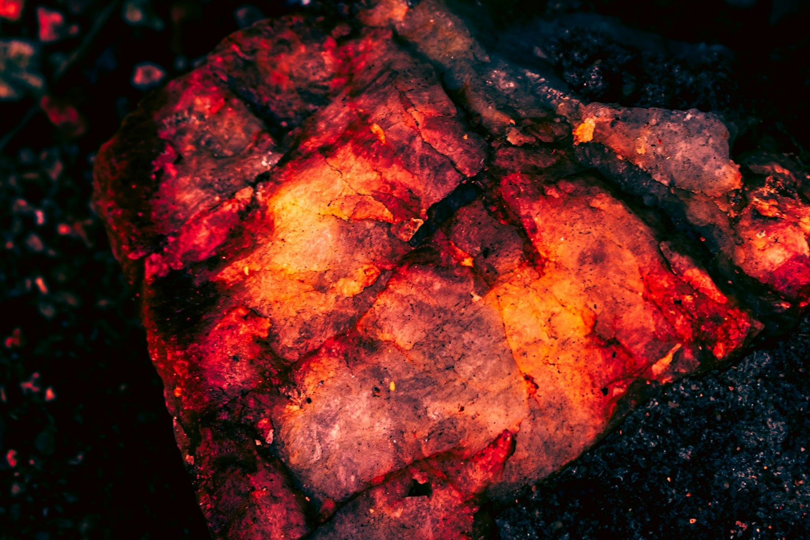 A glowing red and orange ember on a dark background.