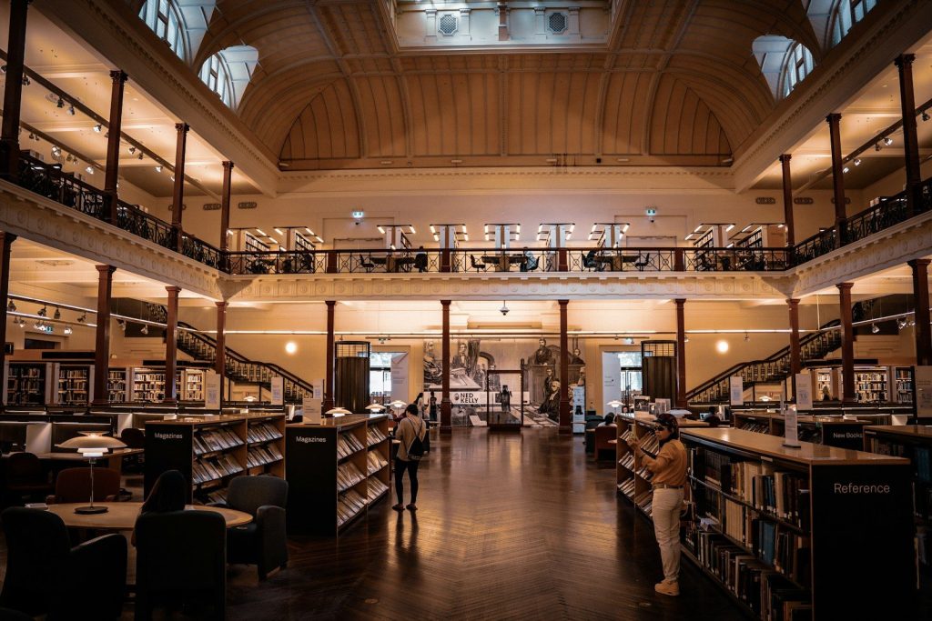 Grand interior of a library with bookshelves and people