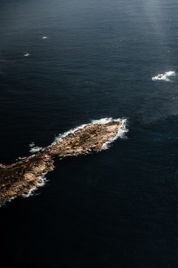 Aerial view of a rocky island in dark blue ocean