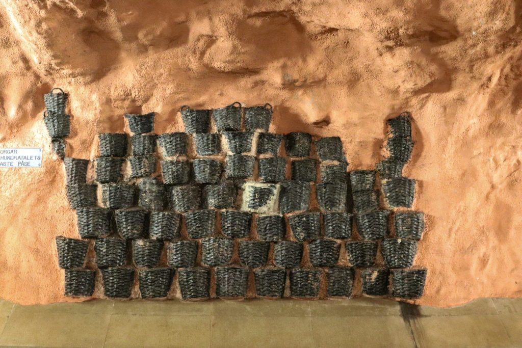 Baskets are stacked up against a wall.