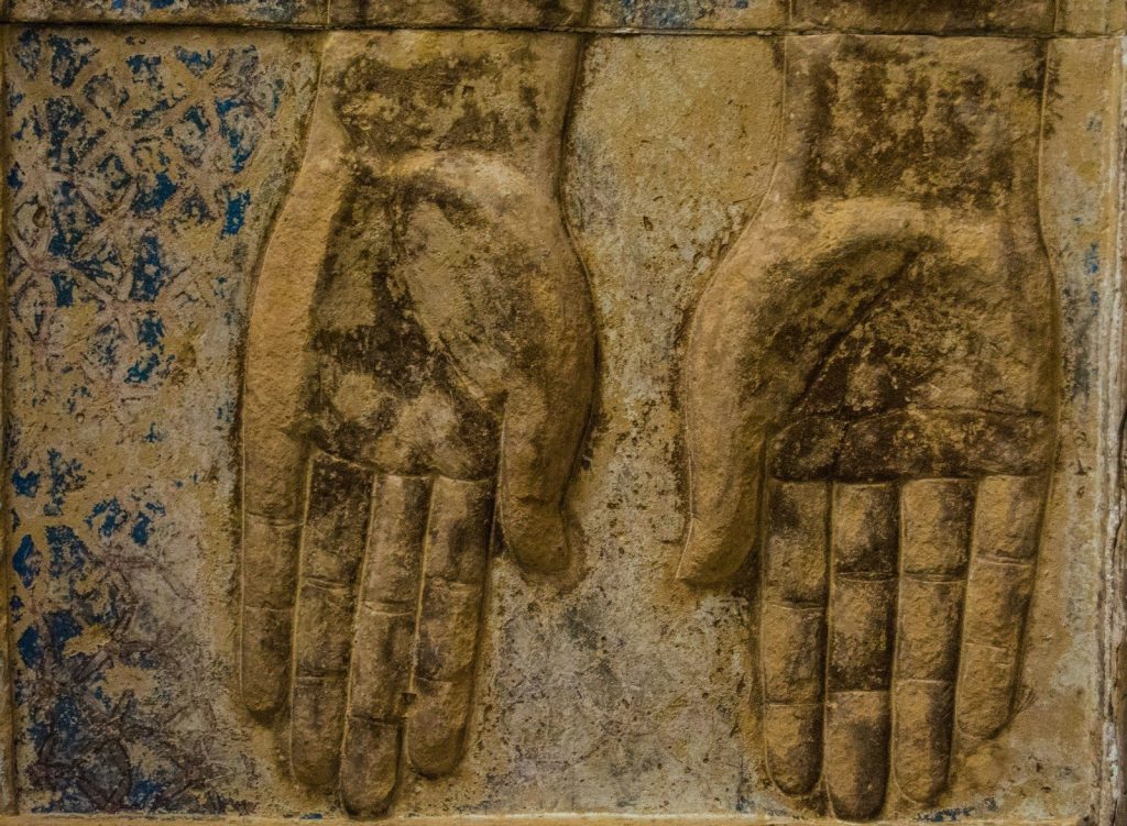 a pair of hands carved into the side of a building