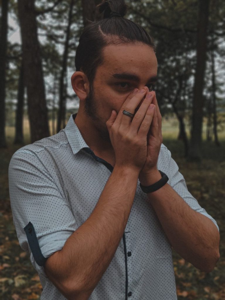 a man covers his face with his hands