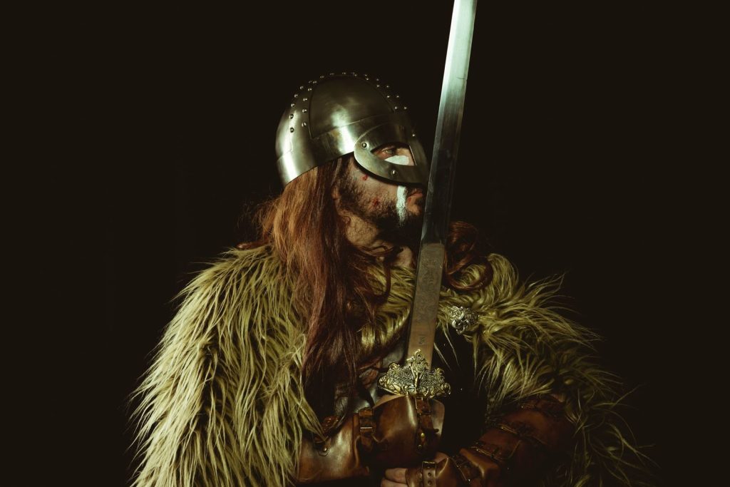 A Viking warrior in armor holding a sword, showcasing historical attire.
