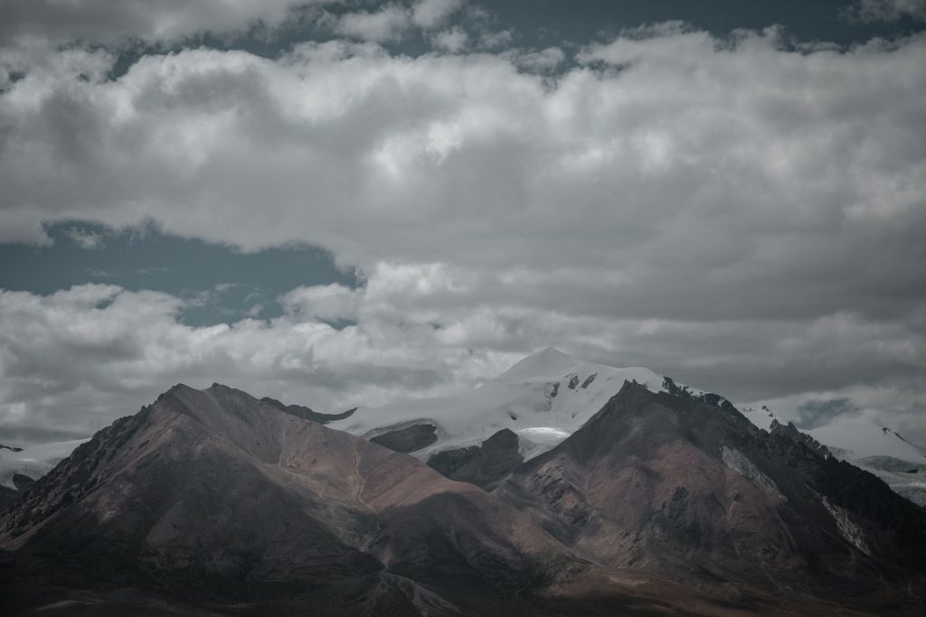 A majestic view of Tibetan mountains under dynamic cloud formations, showcasing natural beauty and serenity.