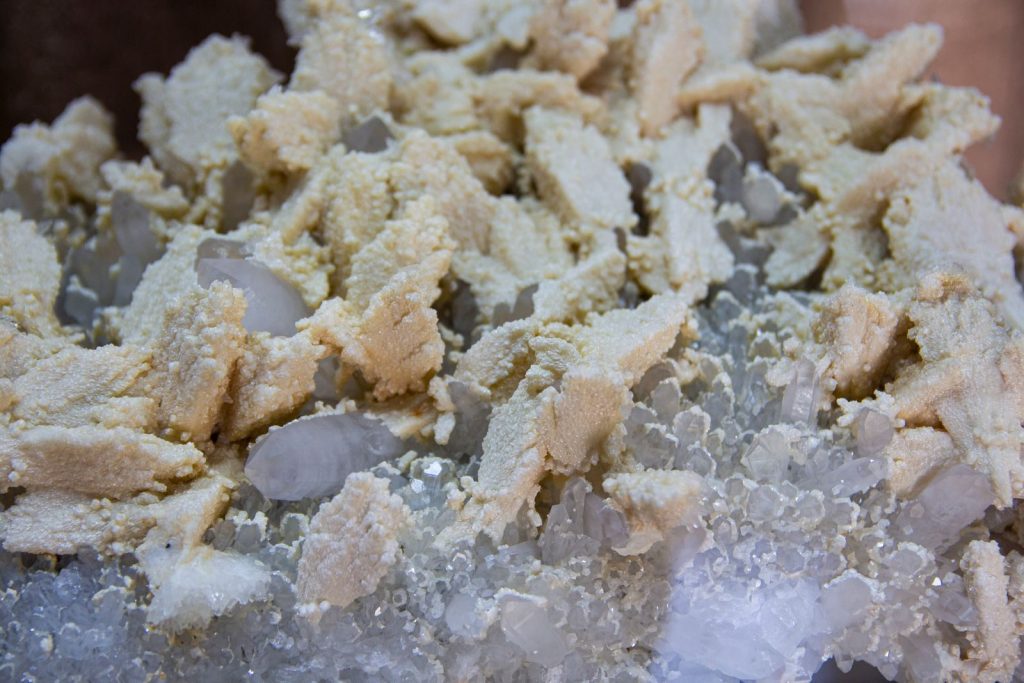 Detailed view of a textured crystal structure with beige mineral deposits.