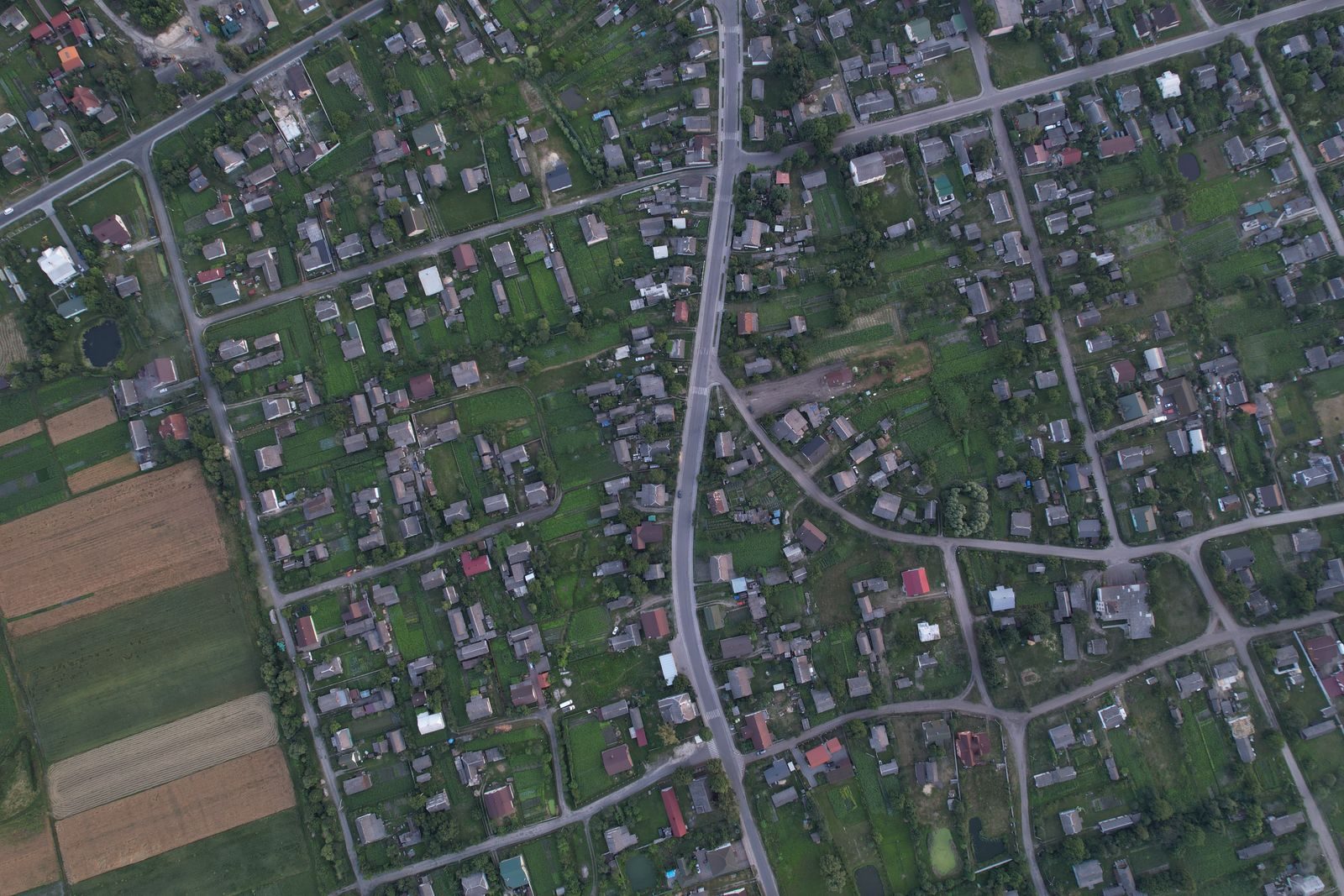 Aerial photo of a residential neighborhood in Shats'k, Ukraine, showcasing green spaces and homes.