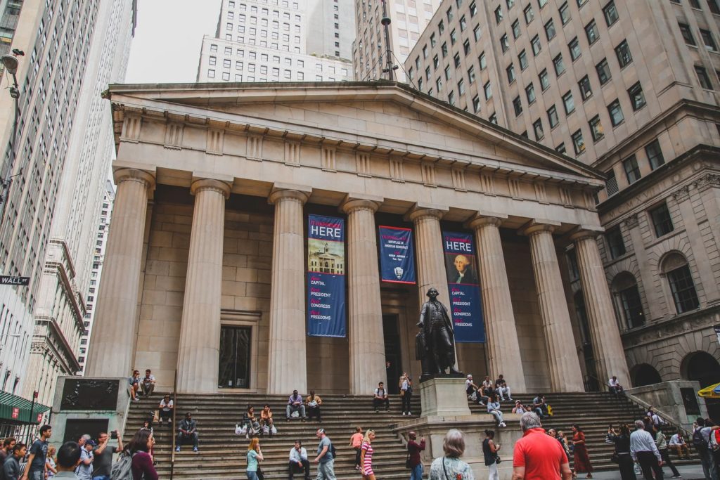 View of Federal Hall with George Washington statue and people in New York City.