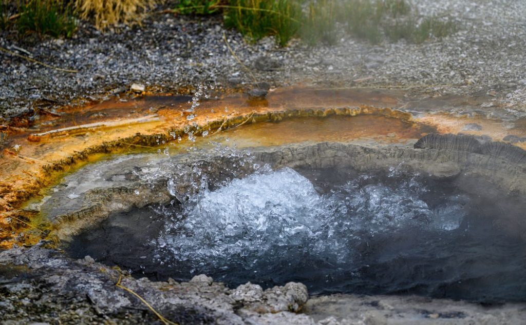 A vivid close-up of a geyser eruption capturing water splashes and colorful minerals.