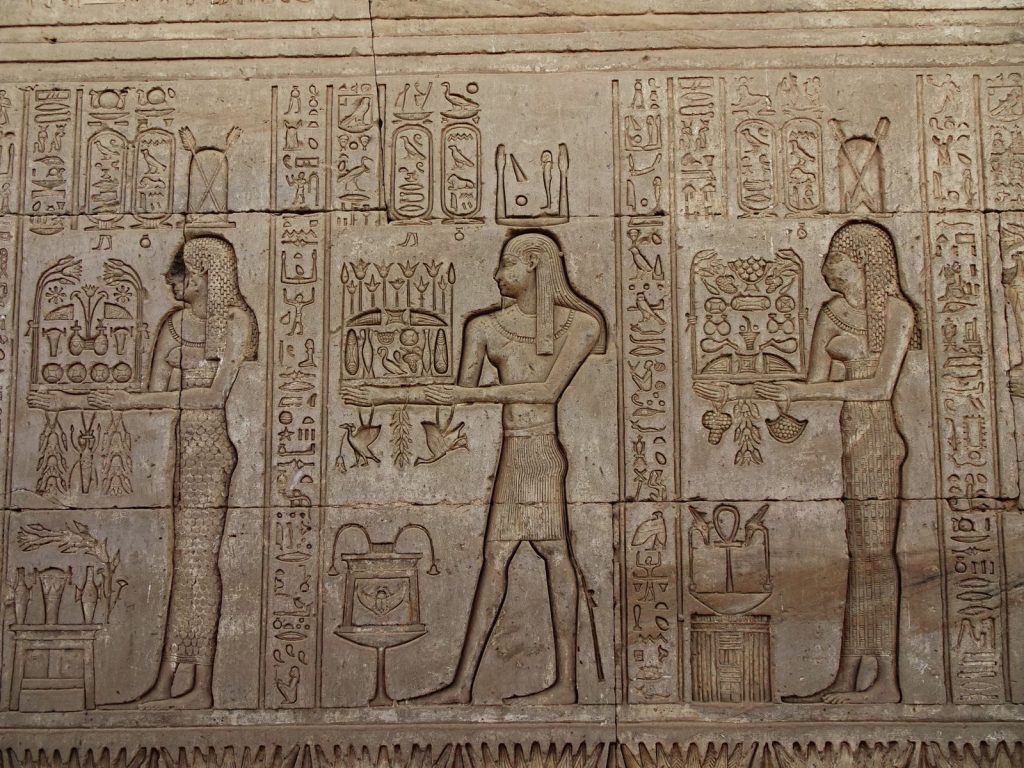 Detailed stone carvings of Egyptian hieroglyphs on the walls of Dendera Temple, Egypt.