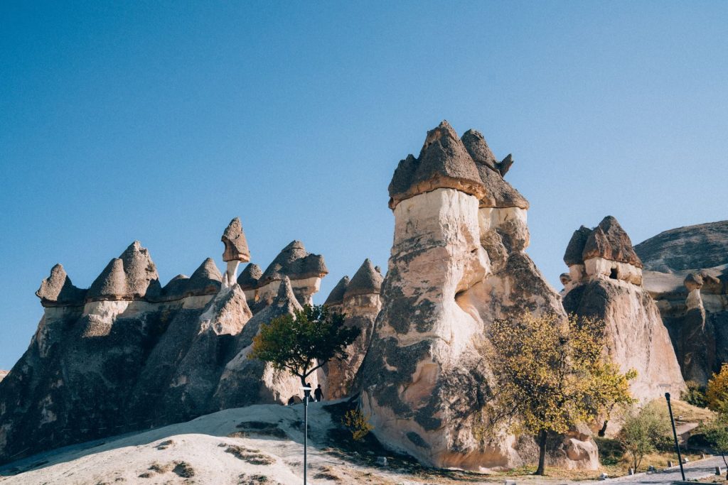Scenic view of Cappadocia's unique fairy chimney rock formations under a clear blue sky.