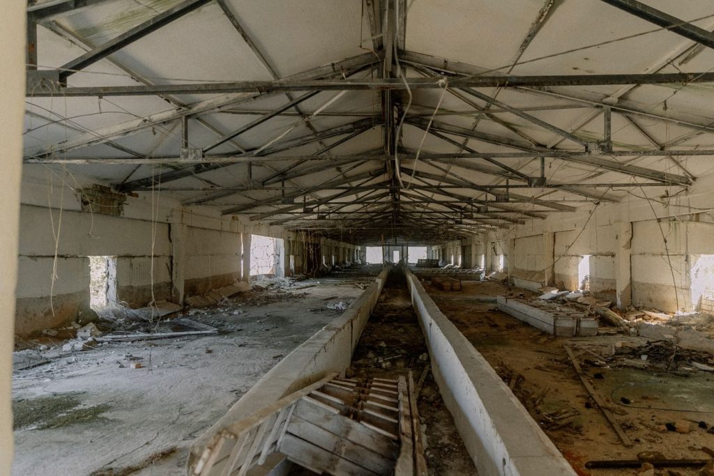 Explore the eerie atmosphere of an abandoned industrial warehouse in ruins.