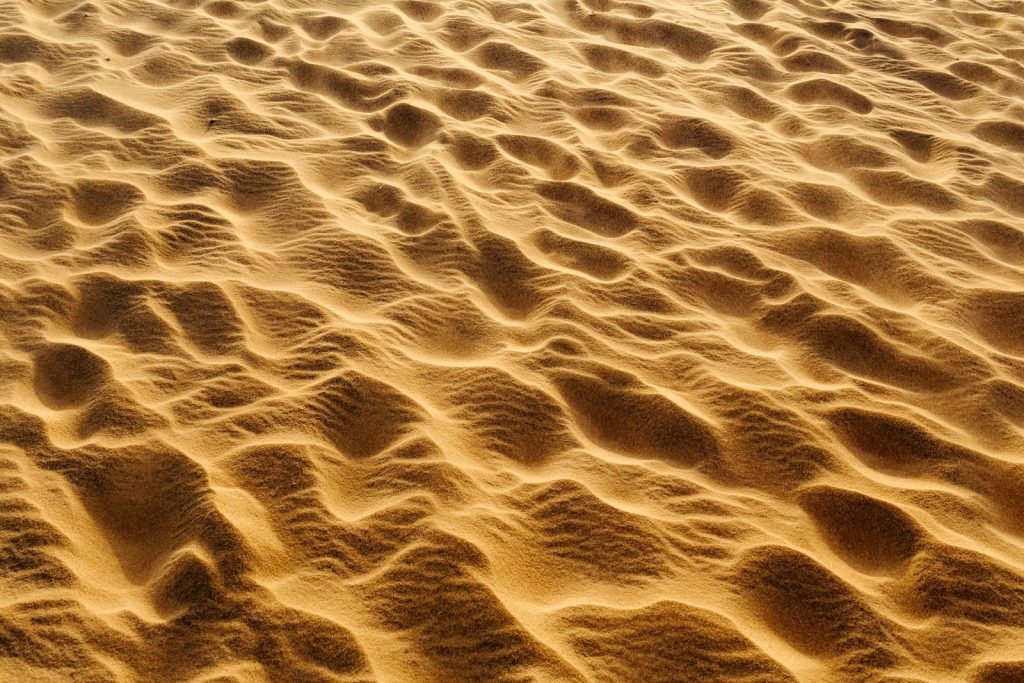 Textured sand dunes with rippling patterns creating a mesmerizing desert landscape.