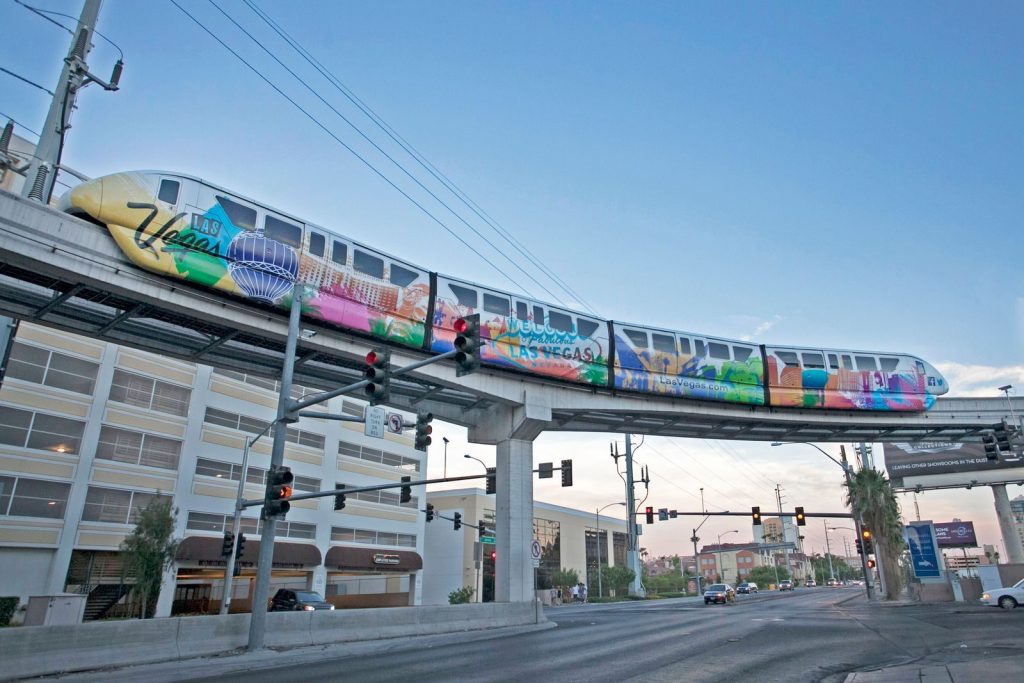 Vibrant Las Vegas monorail captured above city streets, showcasing urban transit charm.
