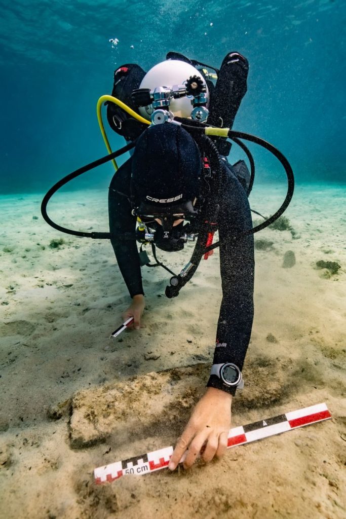 Scuba diver measures underwater artifacts with precision near Croatian coast.