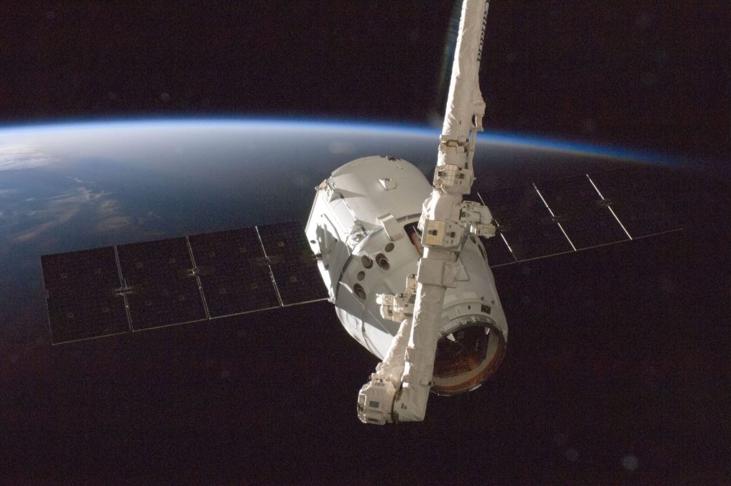 A satellite orbiting Earth with a view of the planet from space.