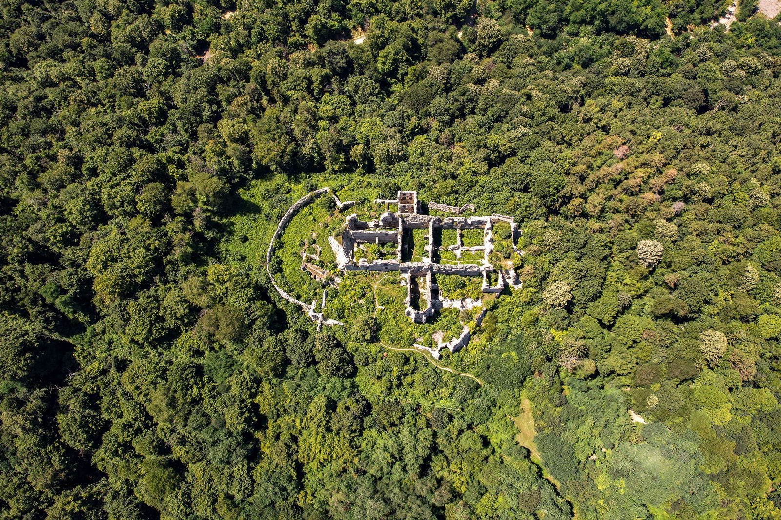 Explore historic ruins hidden within lush forests in Orahovica, Croatia from above.