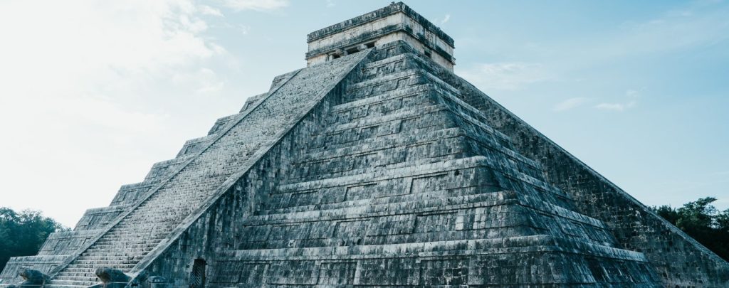Majestic view of the ancient Mayan pyramid at Chichen Itza under a clear sky.