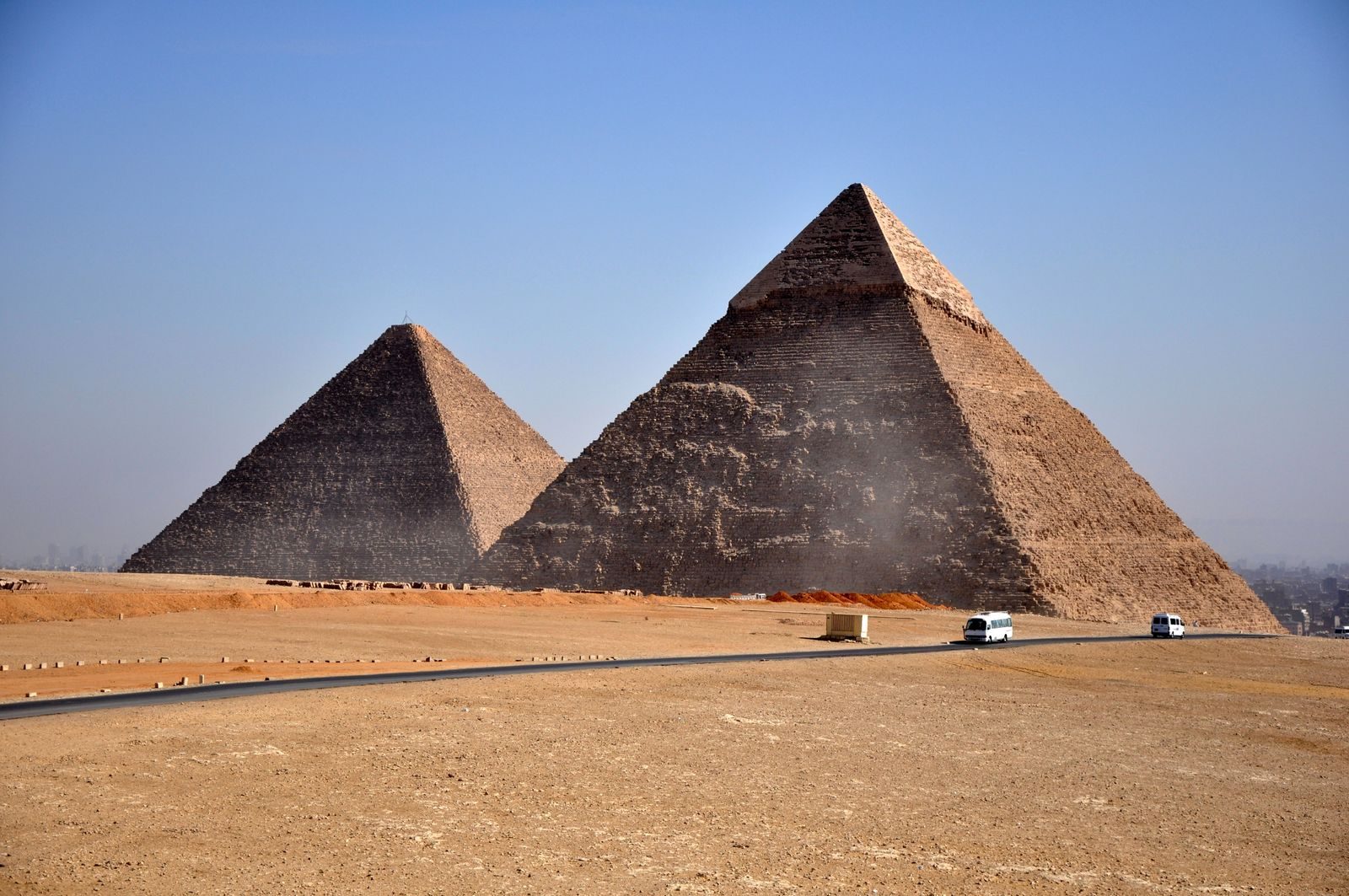 Iconic pyramids of Giza standing under a clear blue sky, showcasing ancient Egyptian architecture.