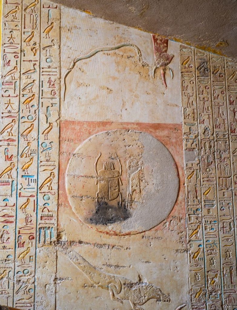 Detailed view of Egyptian hieroglyphs and carvings on a historic temple wall.