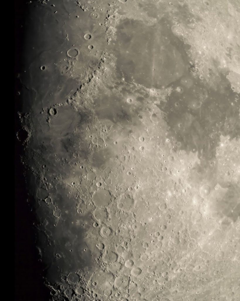 Detailed lunar surface photo highlighting craters and texture under sunlight.