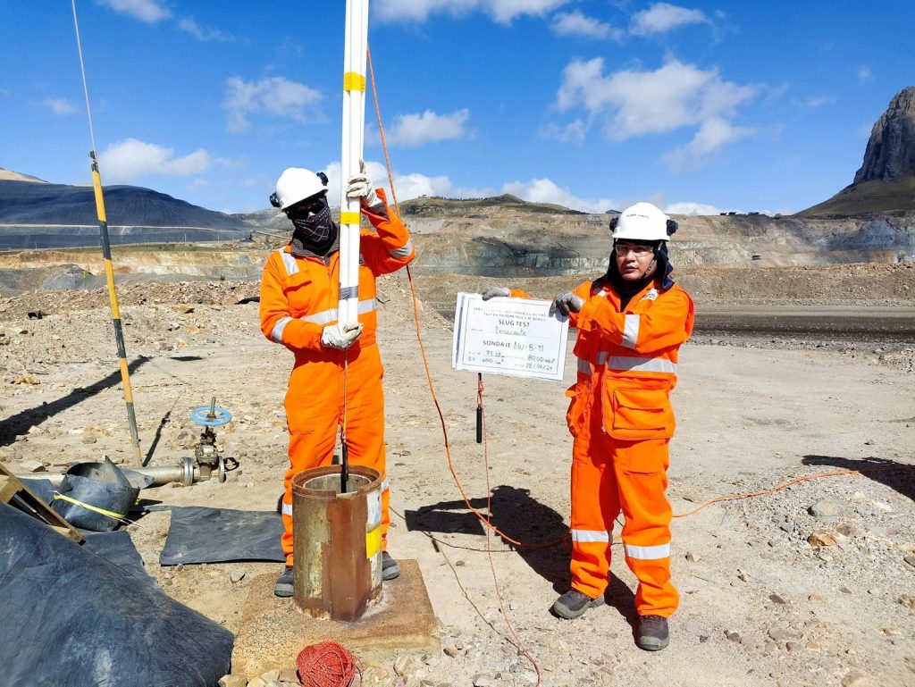 Two men in orange work in a desert
