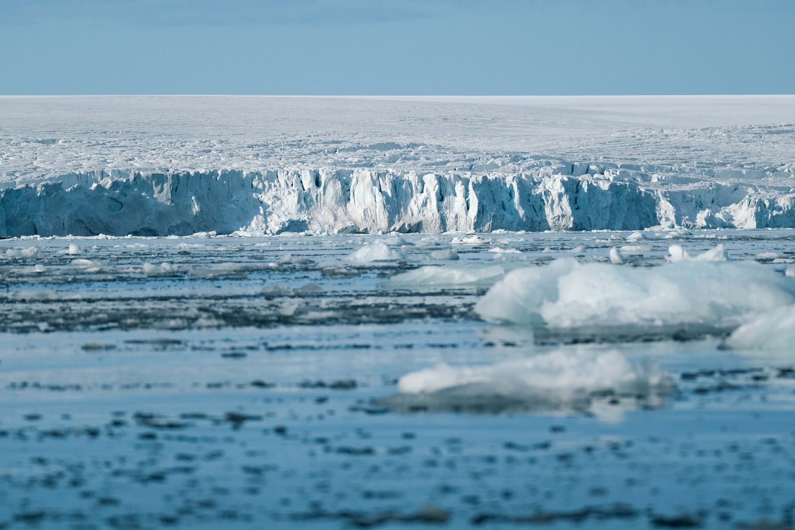 Expansive ice shelf and frozen sea in the Arctic, showcasing the beauty of the natural glacial landscape.