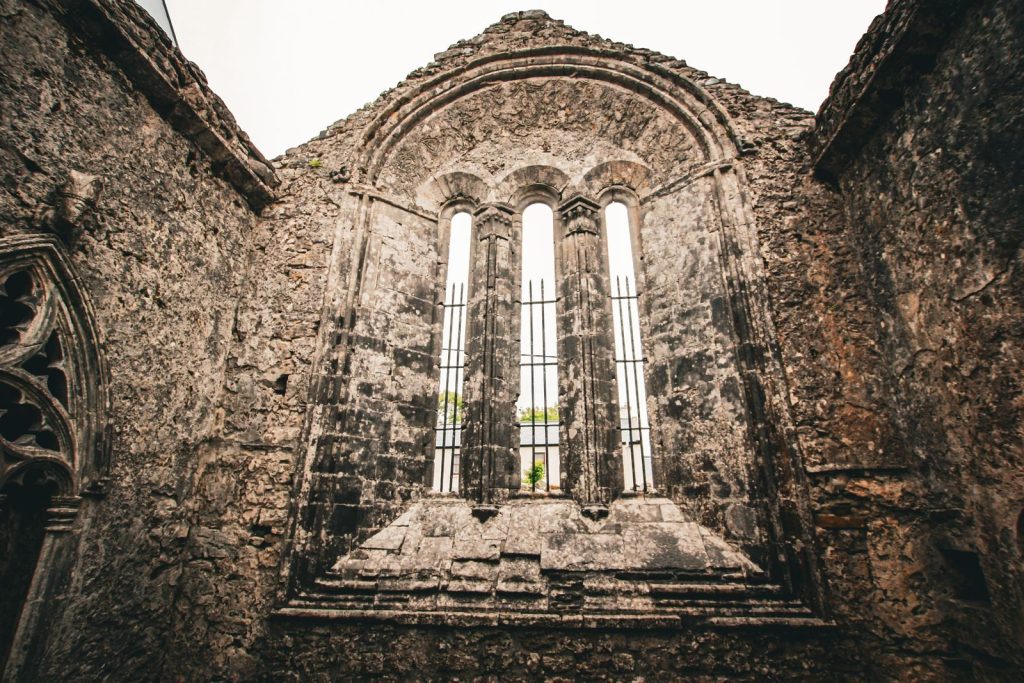 A historic stone ruin with arched windows, showcasing medieval architecture.
