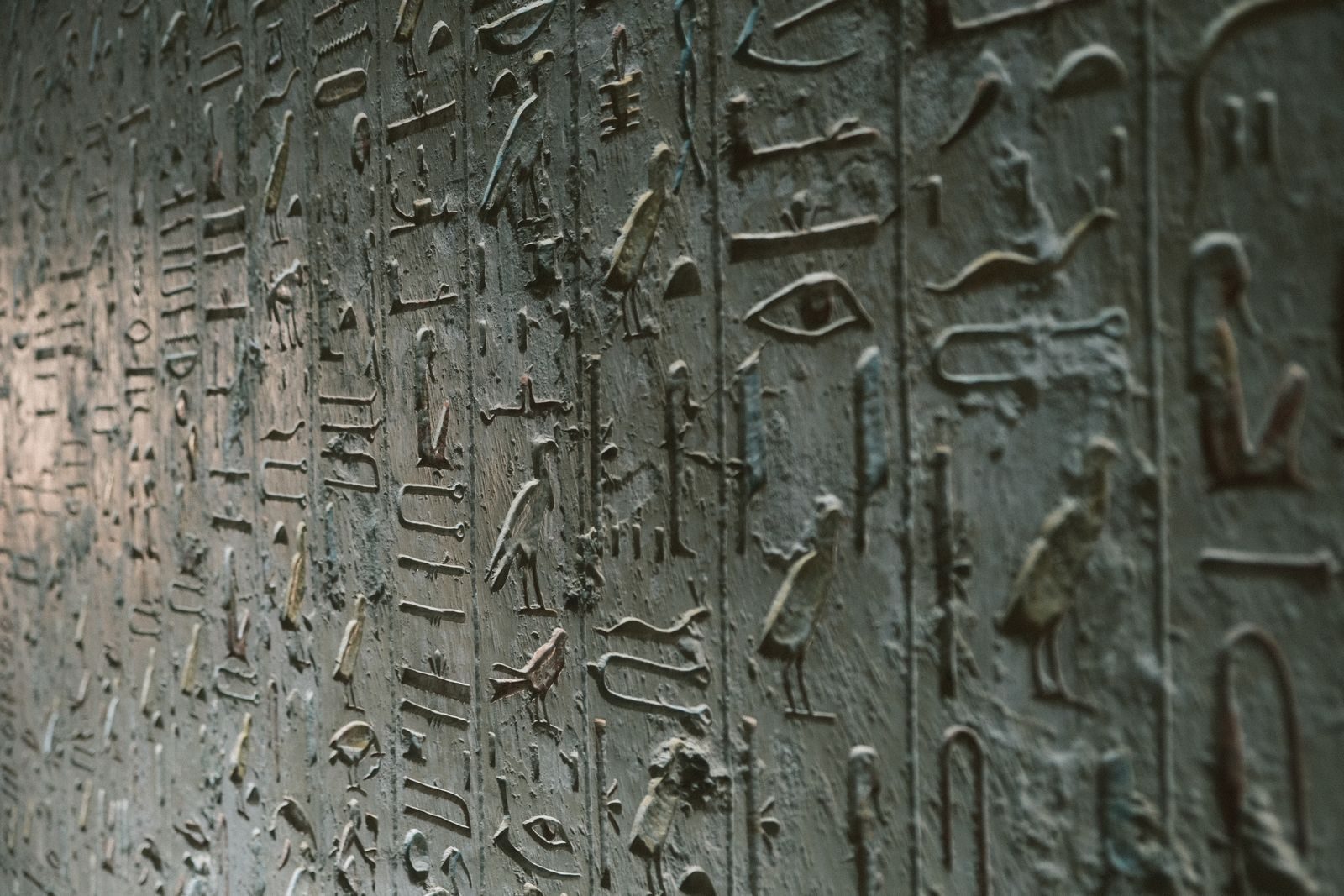 Detailed close-up of ancient Egyptian hieroglyphics on a stone wall in Luxor, Egypt.