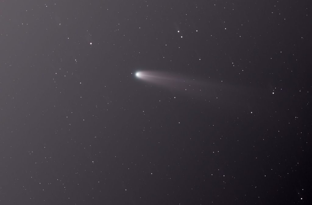 A breathtaking comet streaks across the star-filled night sky, creating a celestial spectacle.