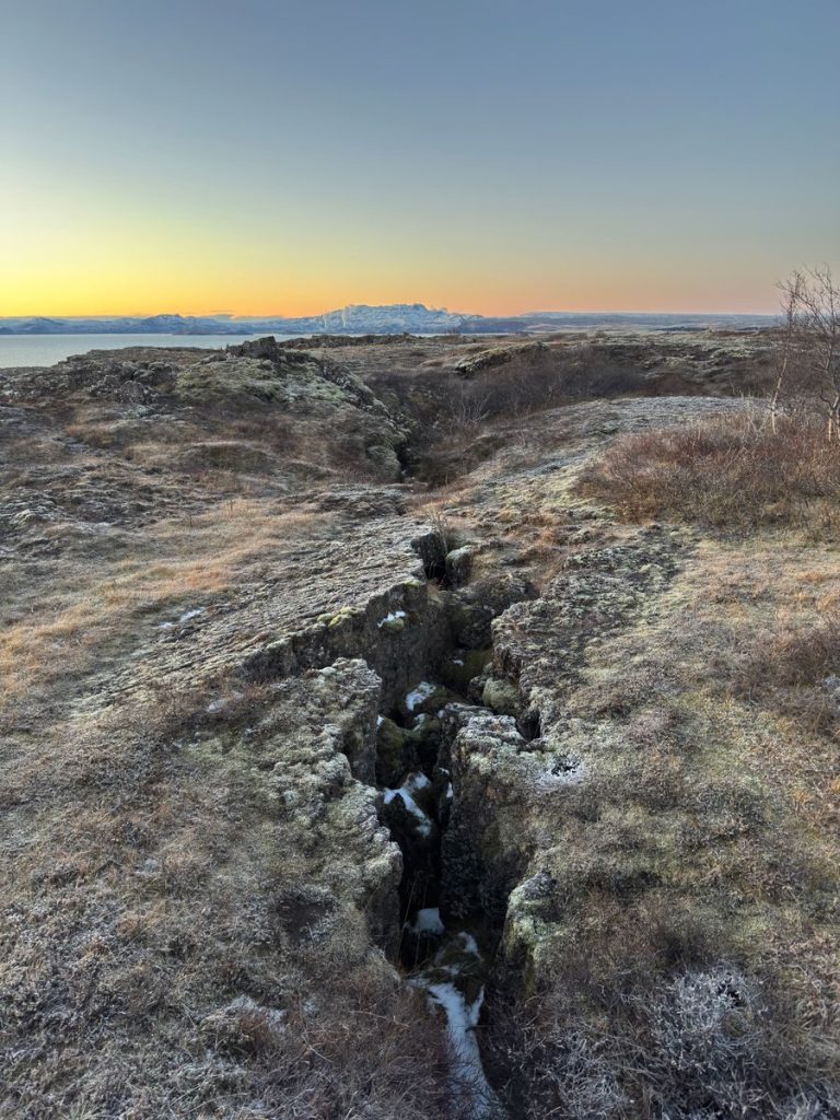 Breathtaking view of Iceland's rocky terrain and distant mountains at sunset.
