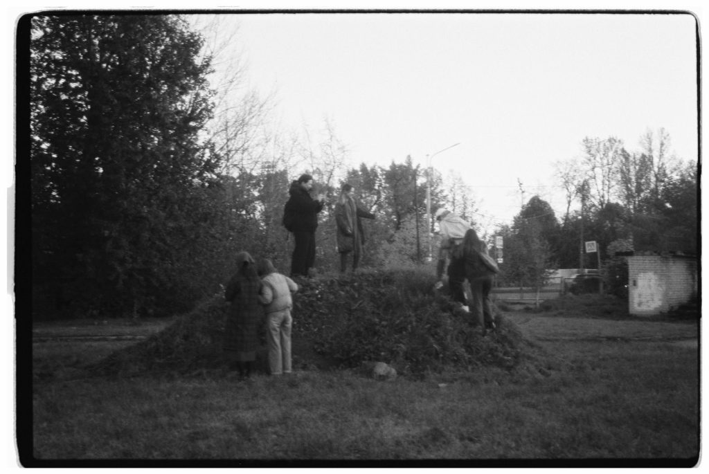Group of people climbing a hill in an outdoor setting captured in black and white.