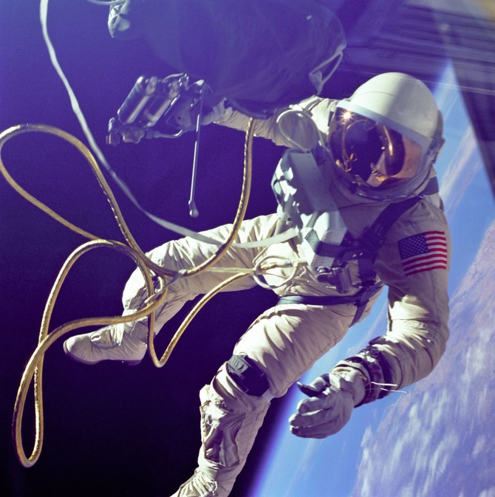 A lone astronaut conducting a spacewalk with Earth visible in the background.