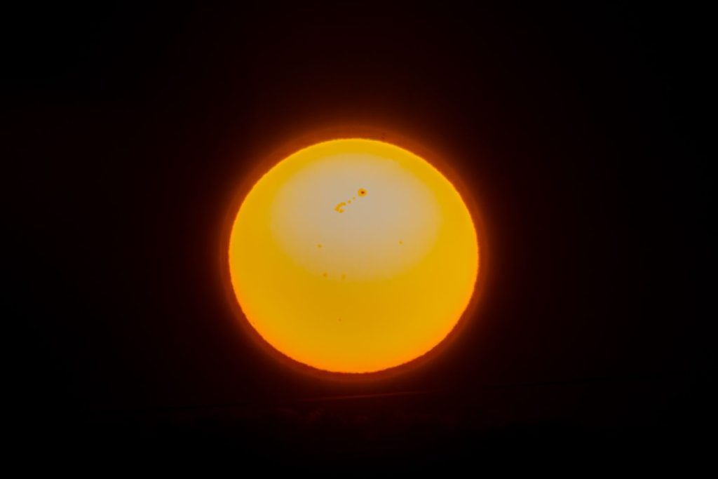 Close-up view of the sun showcasing solar flares and sunspots, captured in a cosmic setting.