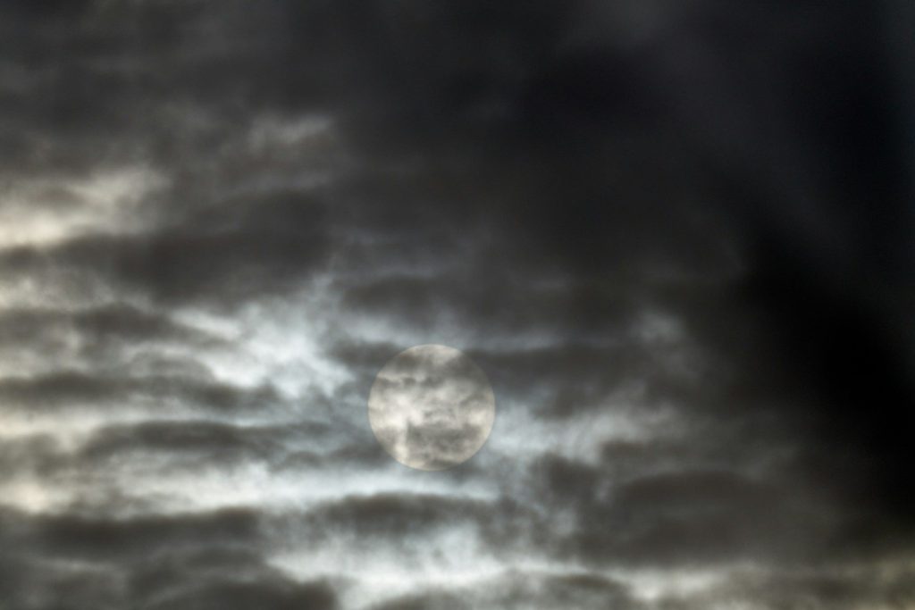 A picture of a cloudy sky with a sun in the middle