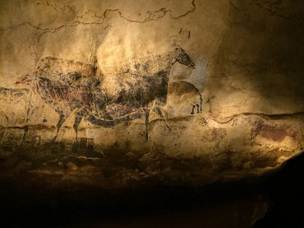 Explore the mysterious ancient cave paintings of horses under warm lighting.
