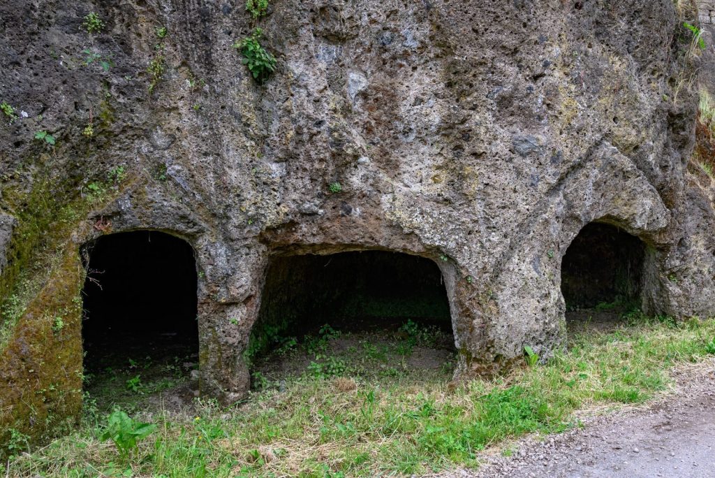 Explore ancient Etruscan tomb carvings in the rocky terrains of Lazio, Italy.