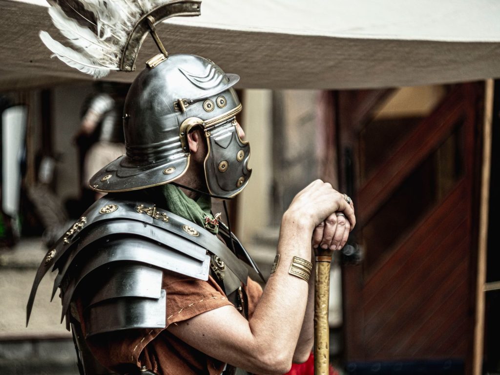 A Roman legionary in full armor, showcasing historical attire with a feathered helmet.