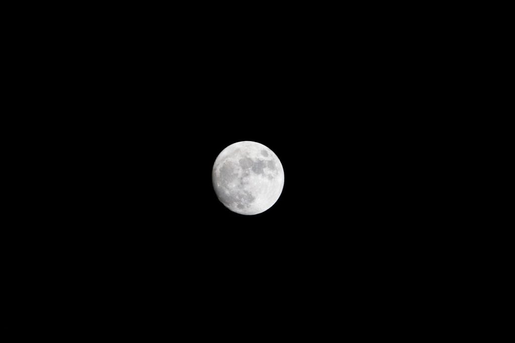 Captivating photo of the full moon against a dark night sky, showcasing lunar details.