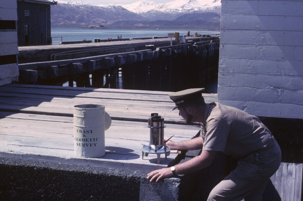 man in brown shirt and black pants sitting on gray concrete bench during daytime